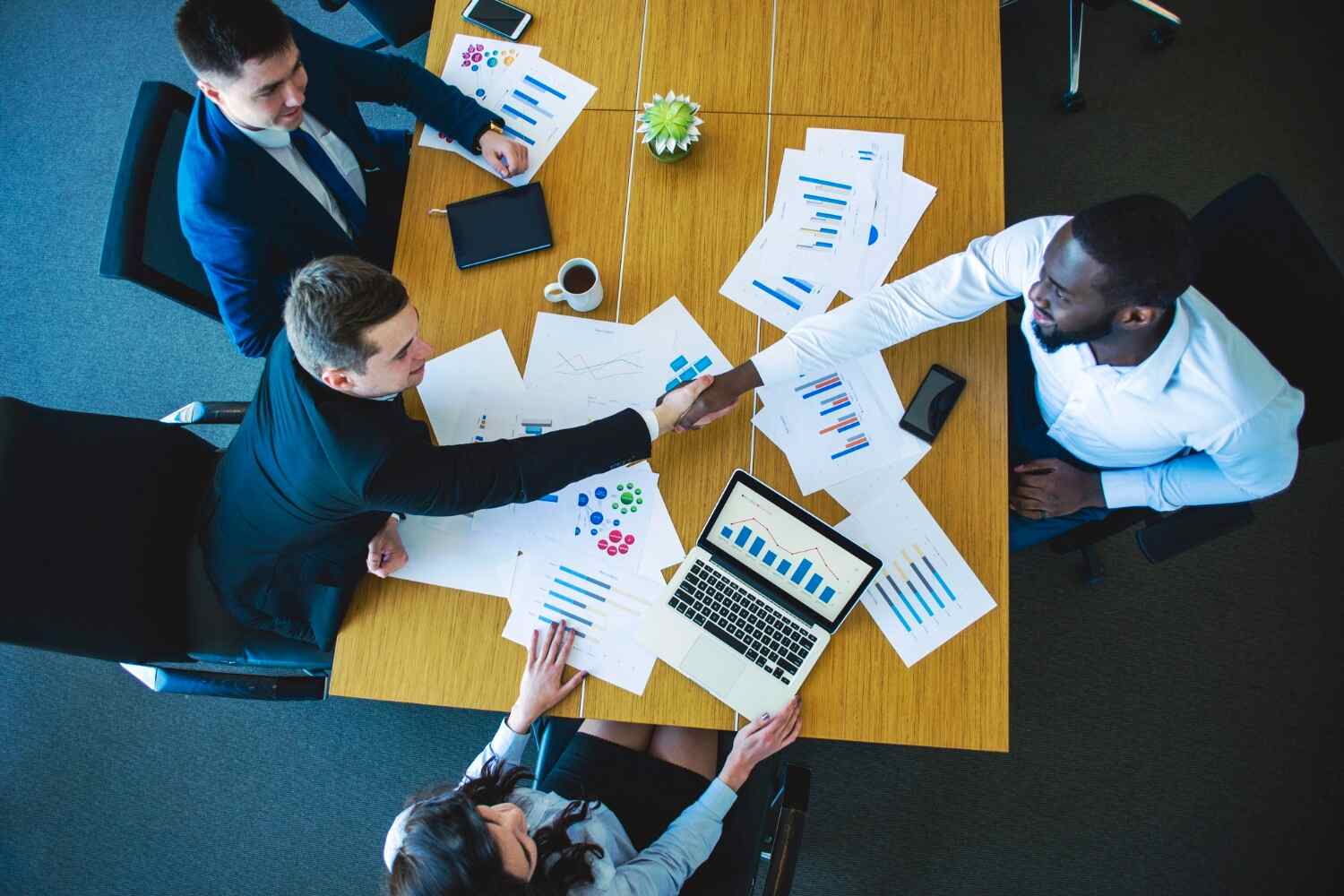 one woman and three men seems happy shaking hands after financial meeting, Choosing the Best Financial Consultancy in Dubai presented by SK Financial Services https://skfinancial.co